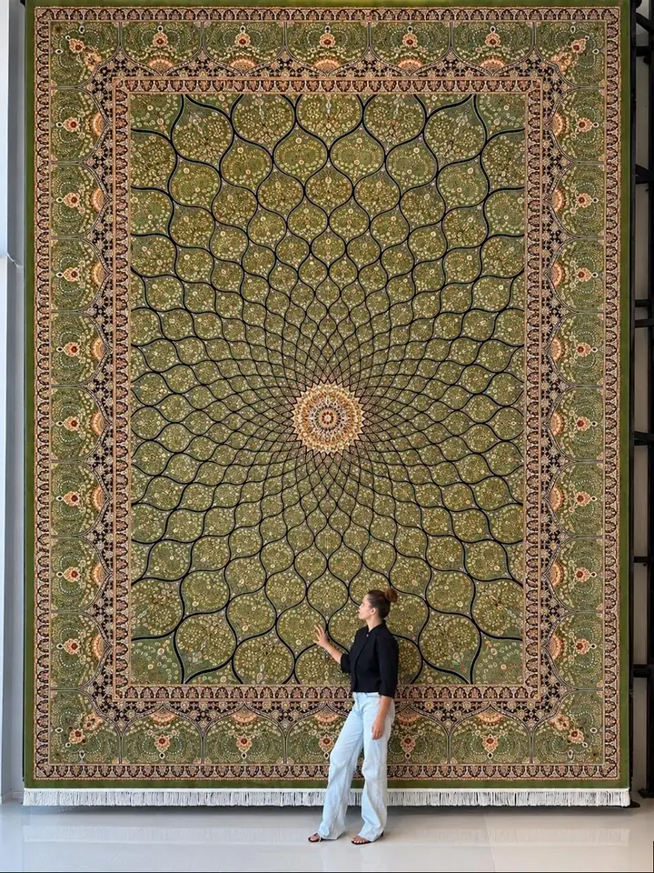 Farnaz Sadeghian beside a large hand-knotted Persian carpet